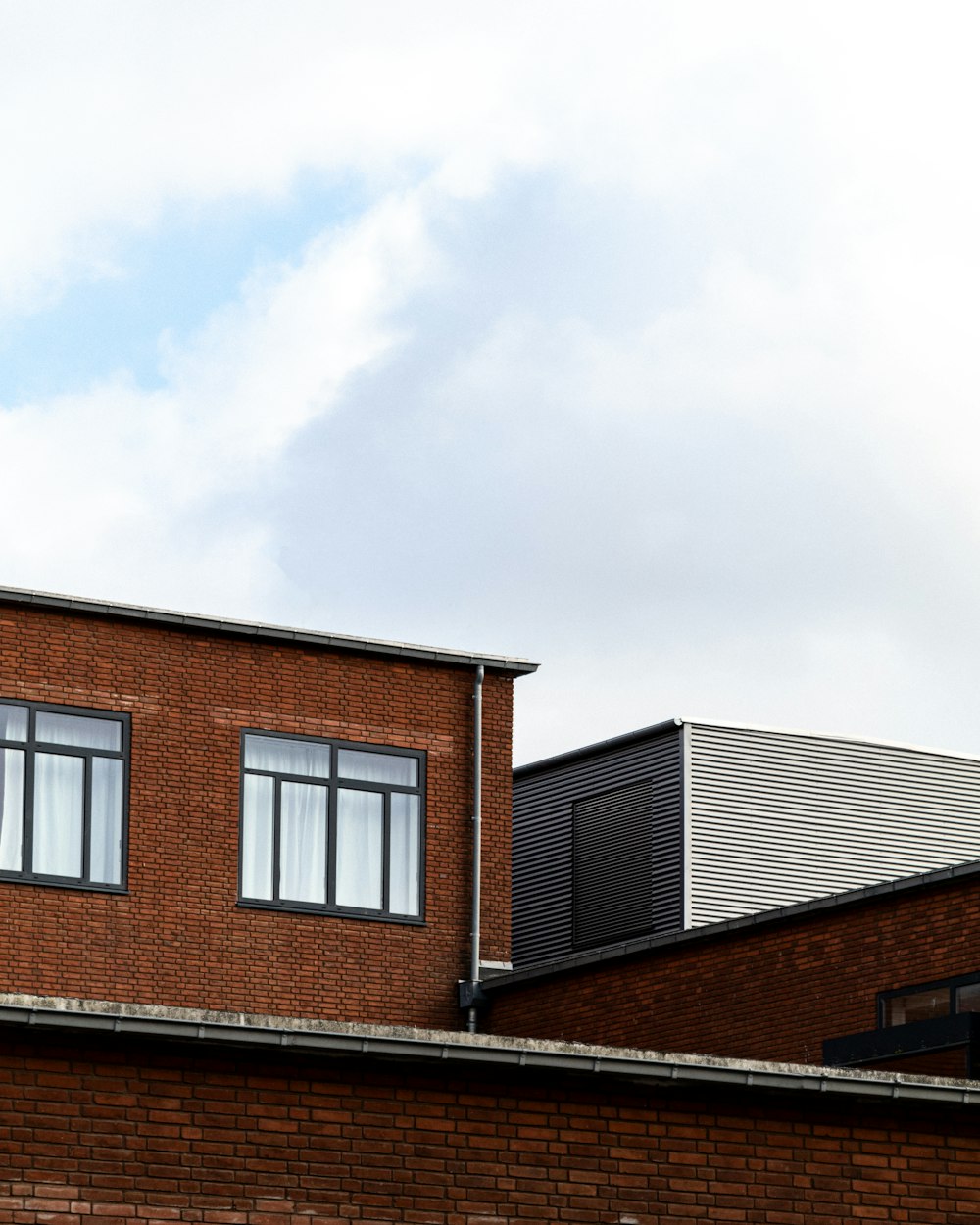 brown brick building under white clouds during daytime