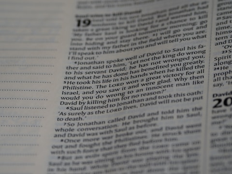 A close-up view of a page from a book, featuring text with a focus on a specific paragraph. The text includes numbers at the beginning of some lines, indicating verses or sections. The page has a slight beige tint, and the text is in a clear, readable font, resembling that of religious or reference material.