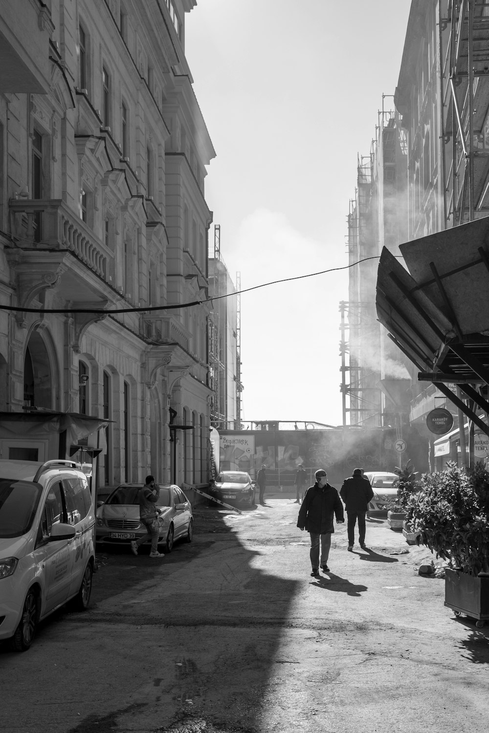 grayscale photo of man walking on street