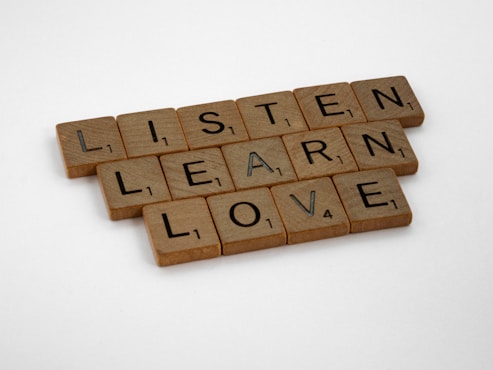 brown wooden blocks on white surface listen learn love