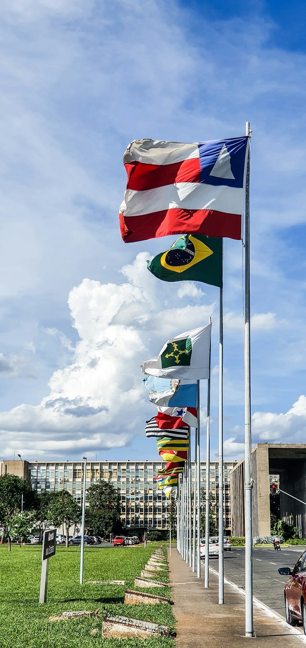 flags under white clouds during daytime
