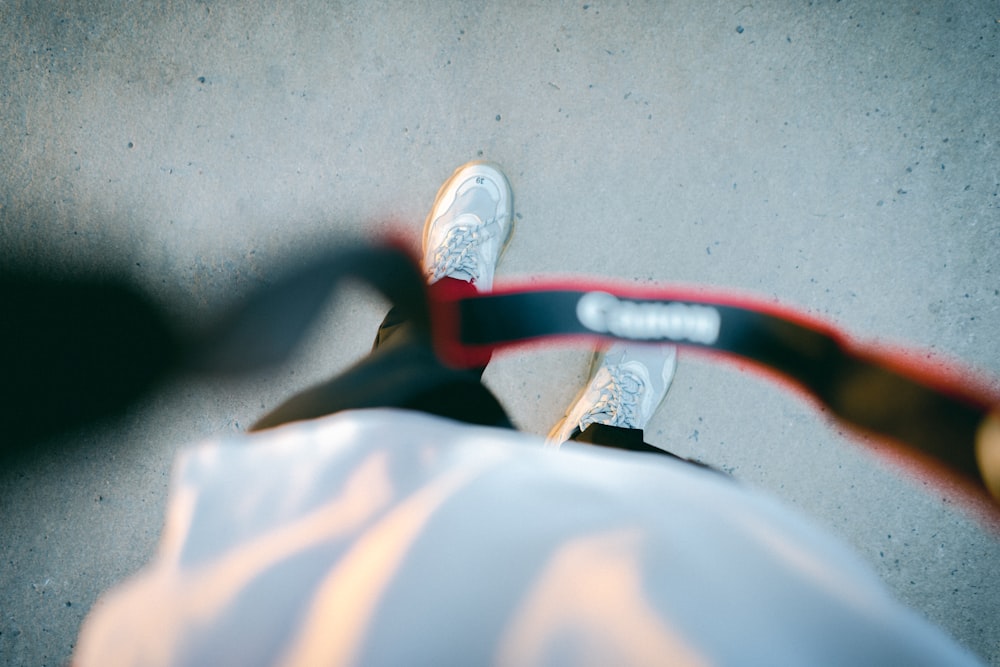 person in white pants wearing white and red sneakers