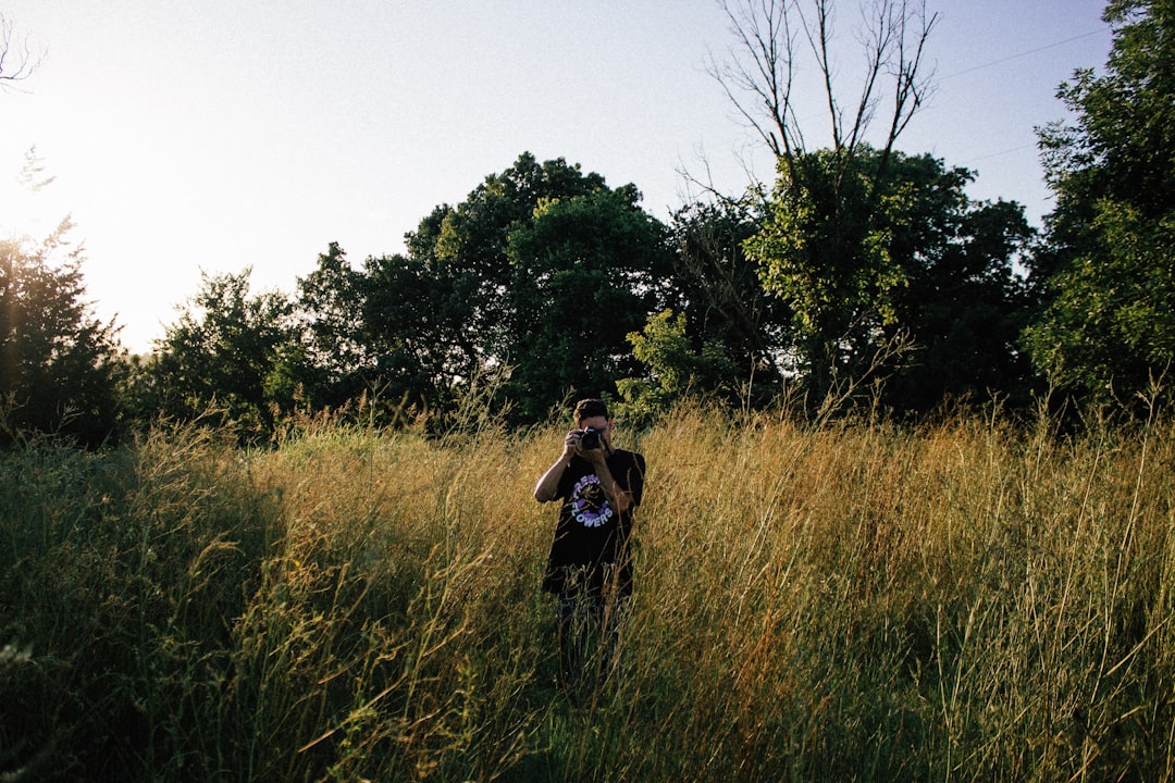 woman in black jacket standing on green grass field during daytime