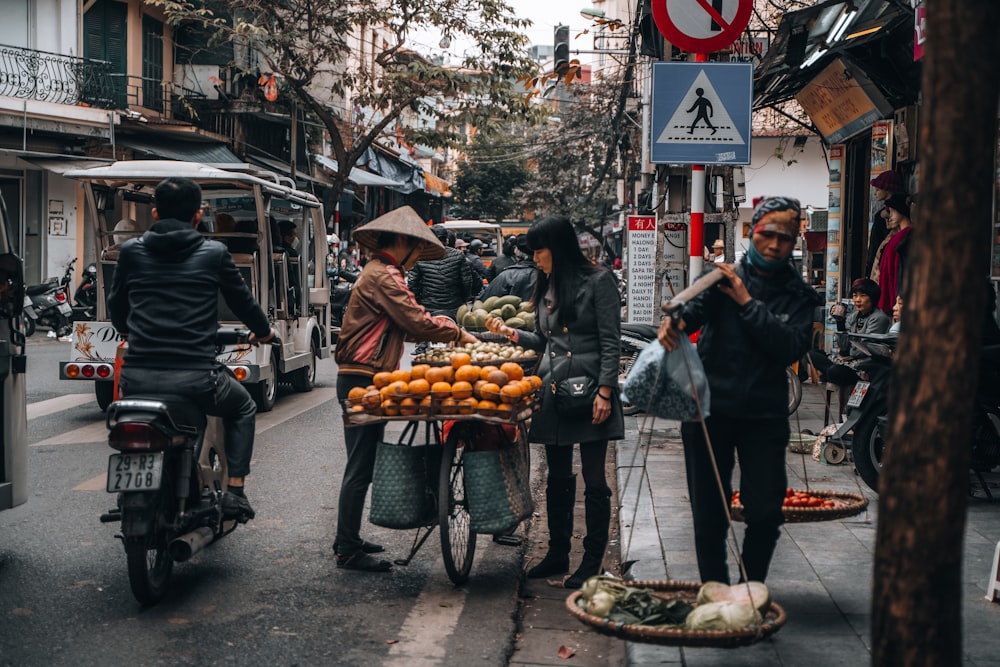 man in black jacket standing near food cart during daytime