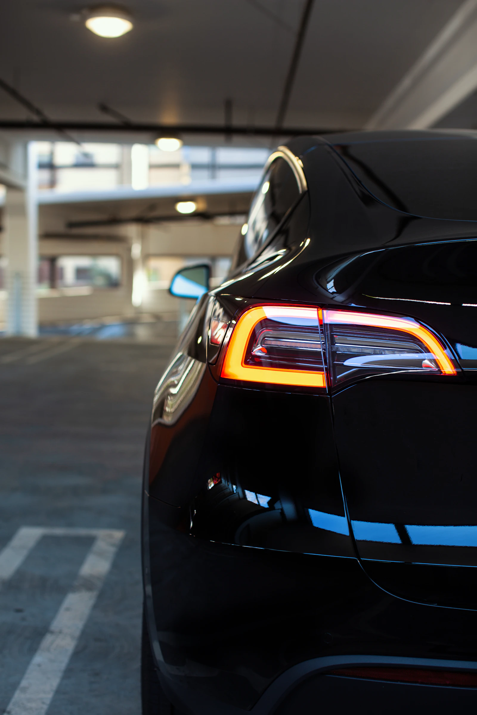 Tesla Model Y electric SUV photographed from a front three-quarter angle on a road, showing the front fascia, headlights and alloy wheels
