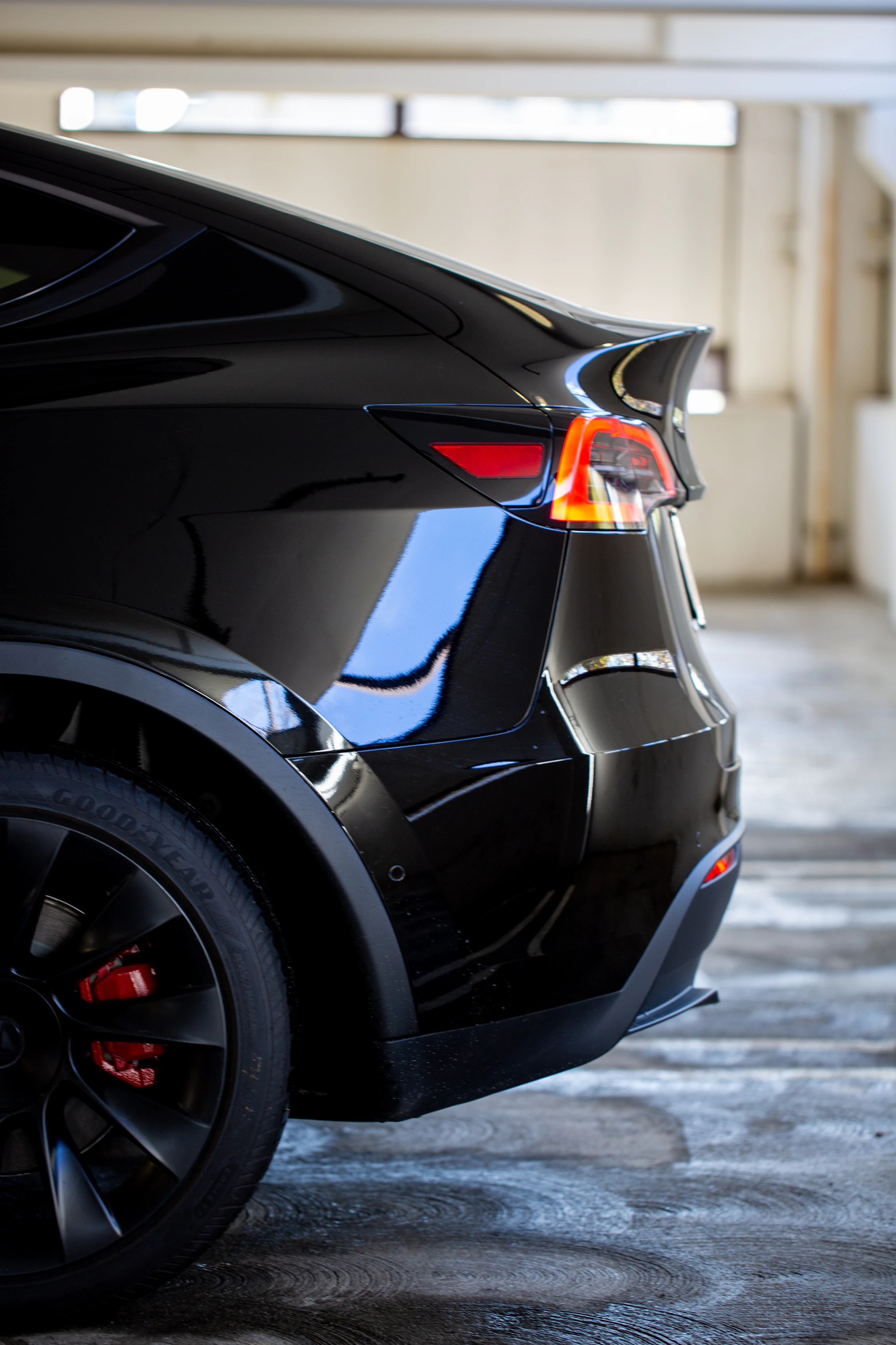 Glossy black electric SUV rear quarter panel after paint refinement