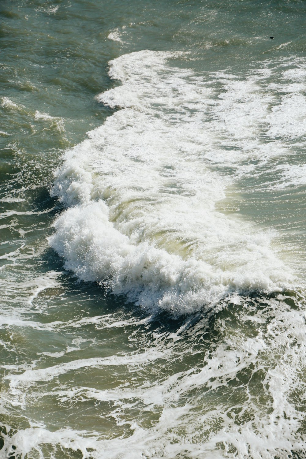 ocean waves crashing on shore during daytime