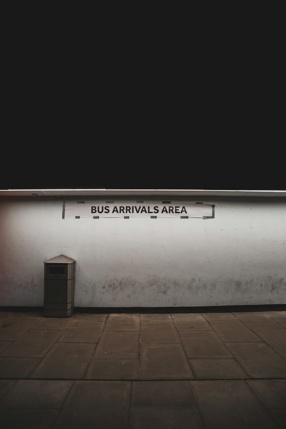 a bus stop with a sign on the side of it