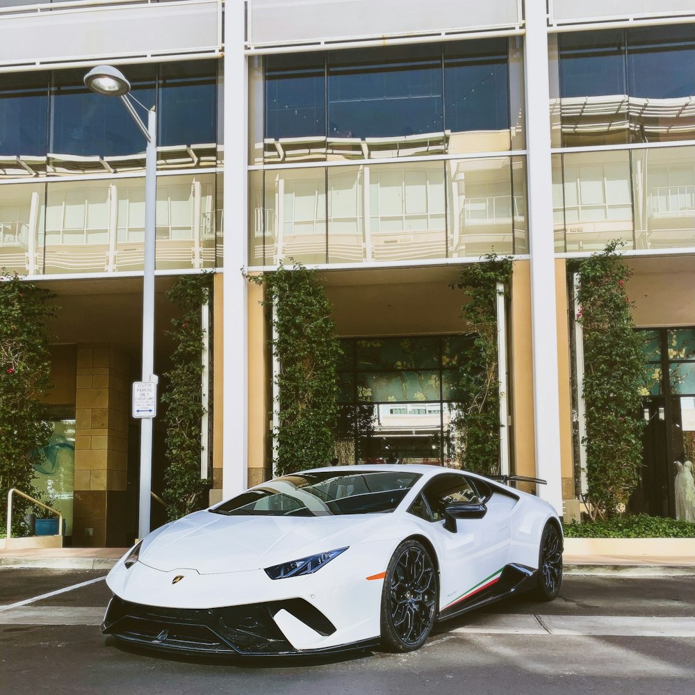 white porsche 911 parked near white building during daytime