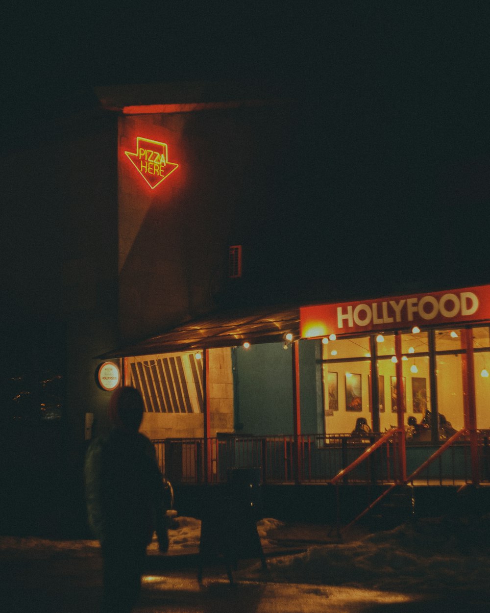 homem em pé perto da loja durante a noite