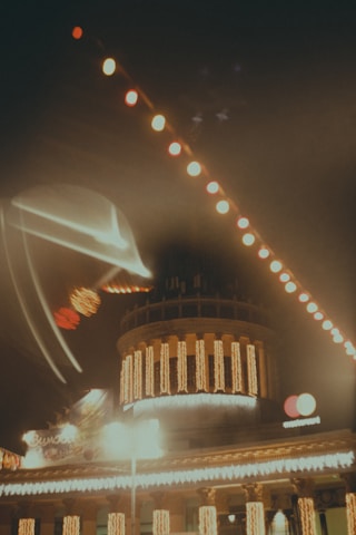 Elegant commercial building adorned with professional Christmas lighting decorations at night.