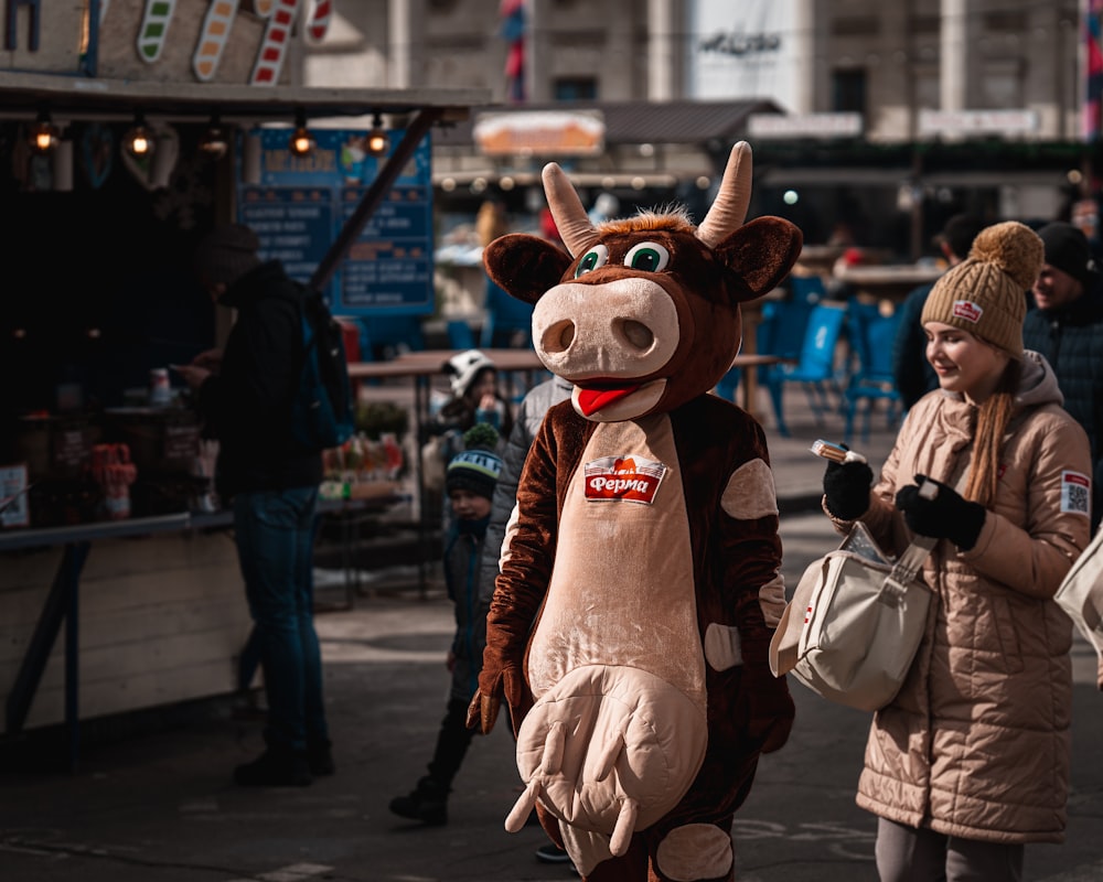 Braun-weißes Hundemaskottchen, das tagsüber auf der Straße steht