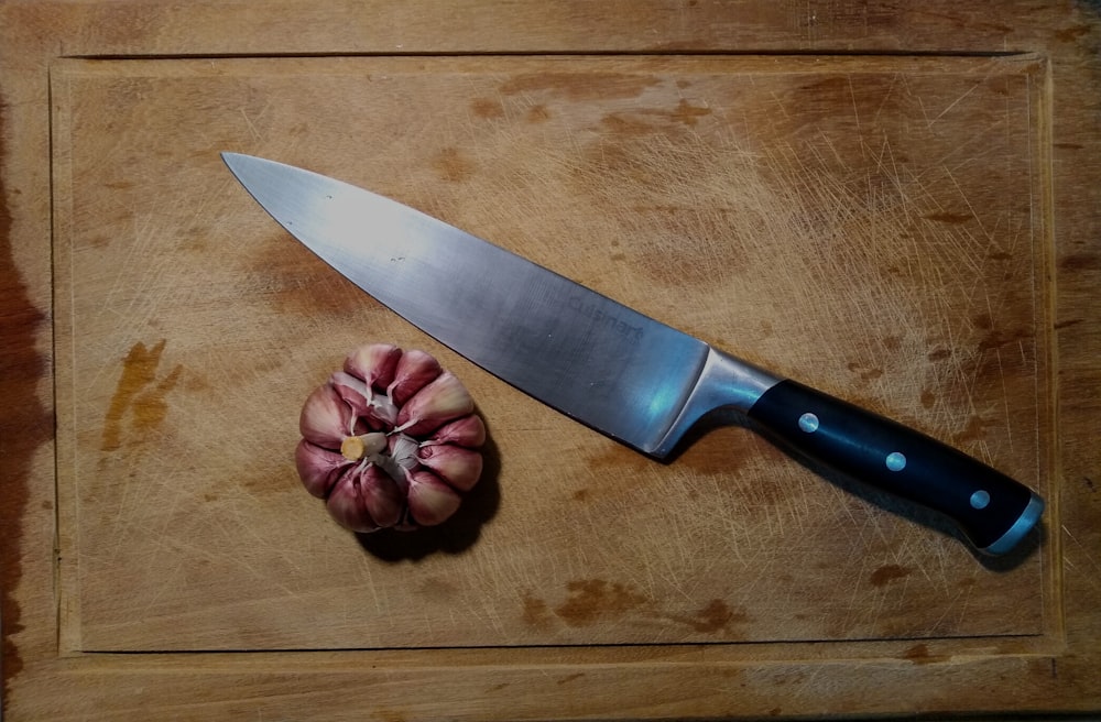 cuchillo de mango negro sobre mesa de madera marrón