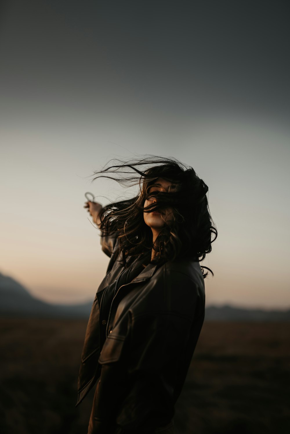 woman in black jacket standing on brown field during daytime