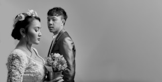 man in black suit jacket holding bouquet of flowers