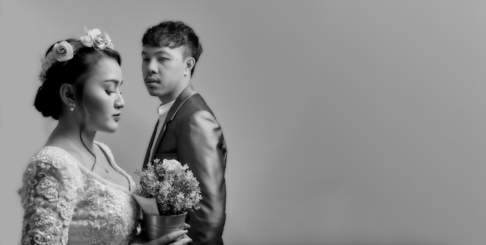 man in black suit jacket holding bouquet of flowers