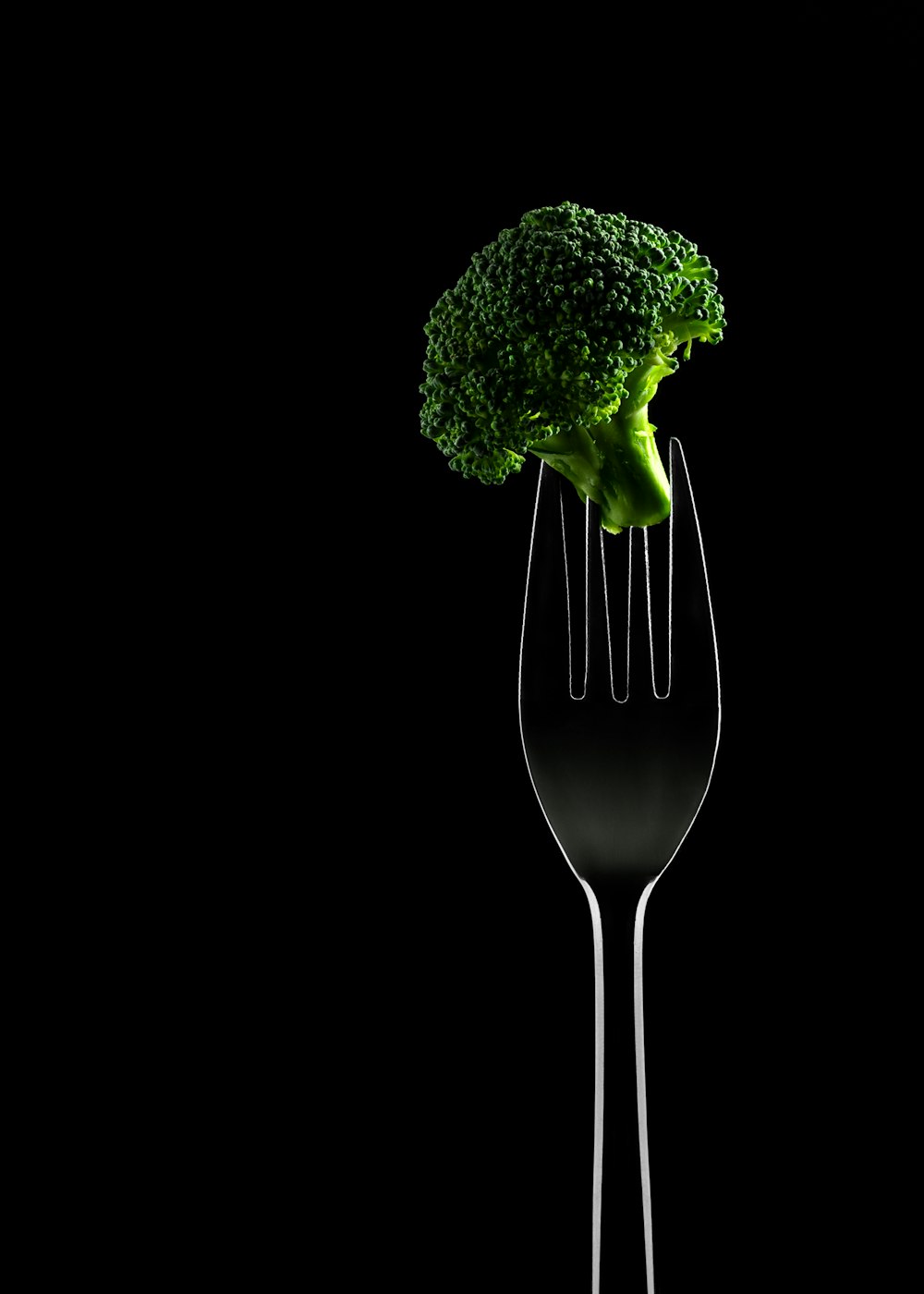 a fork with a piece of broccoli sticking out of it