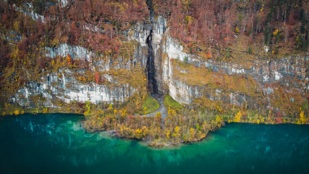 brown and green mountain beside body of water during daytime