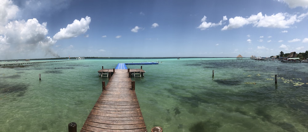 brown wooden dock on sea under blue sky during daytime