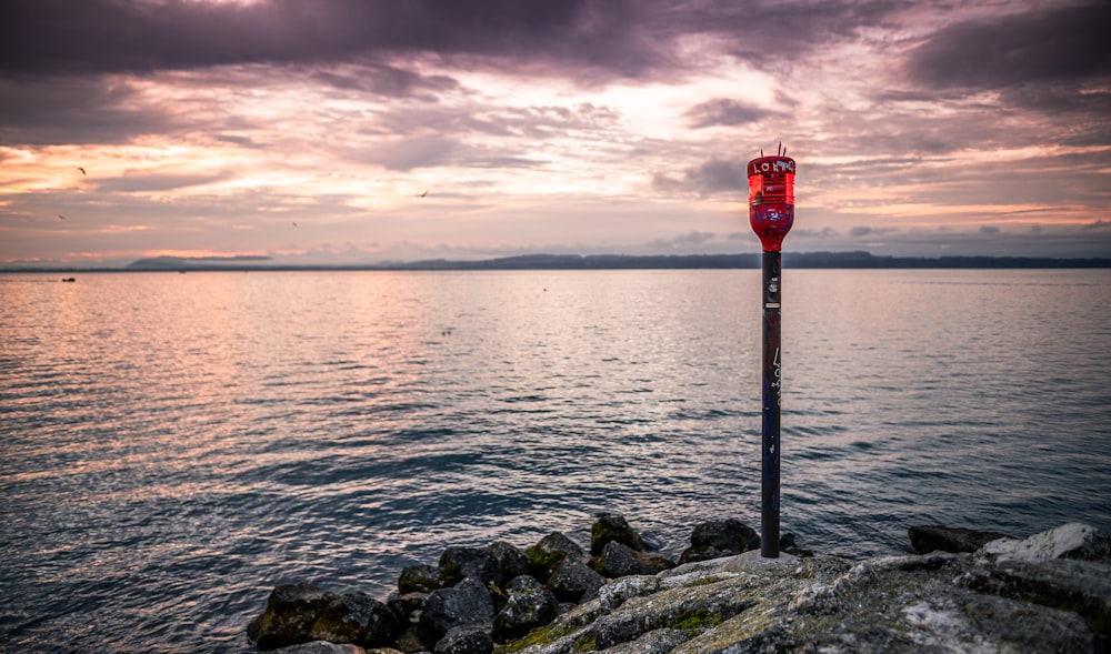 red and white metal stand near body of water during daytime