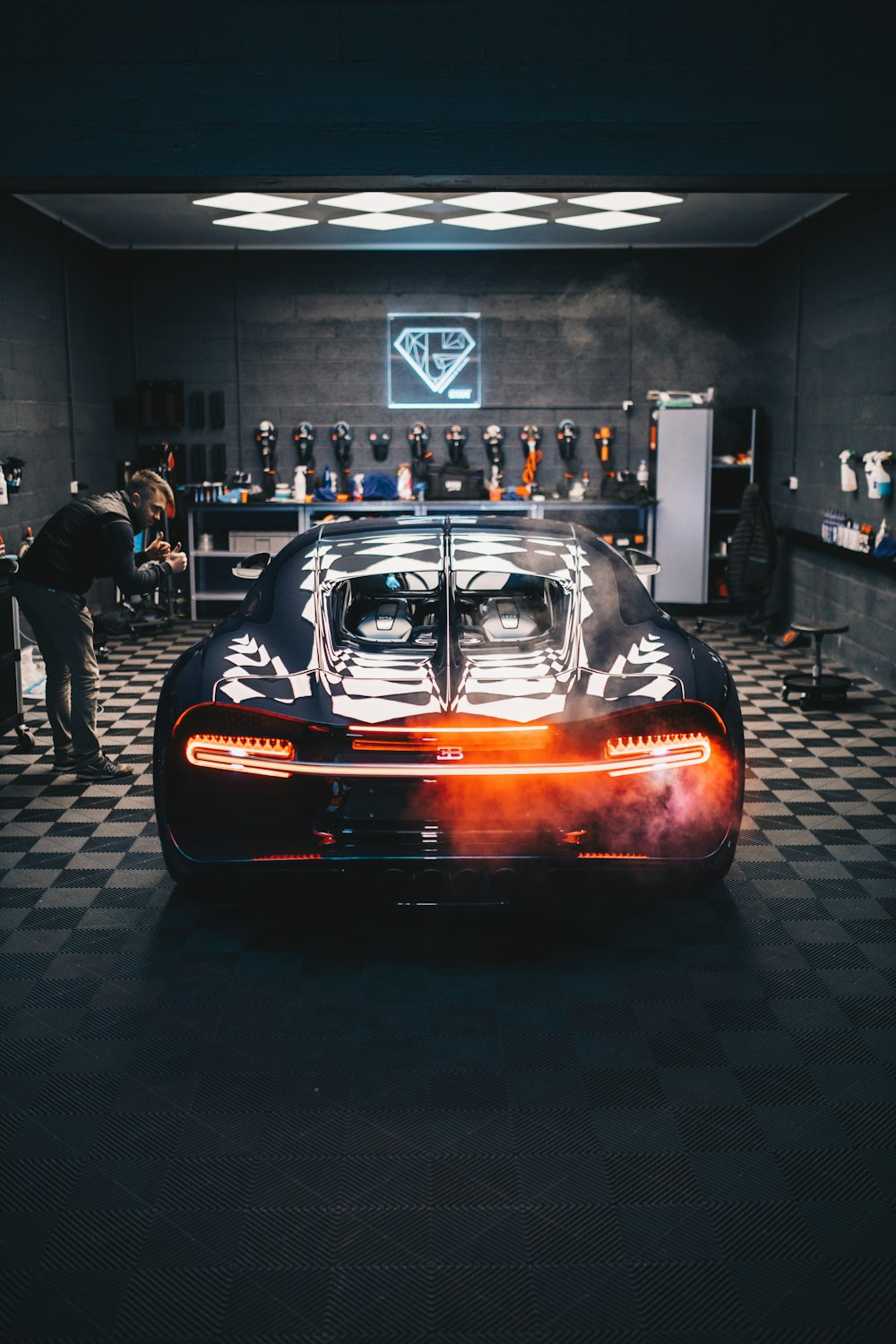 black Bugatti Chiron car in a garage with a man giving a thumbs up 