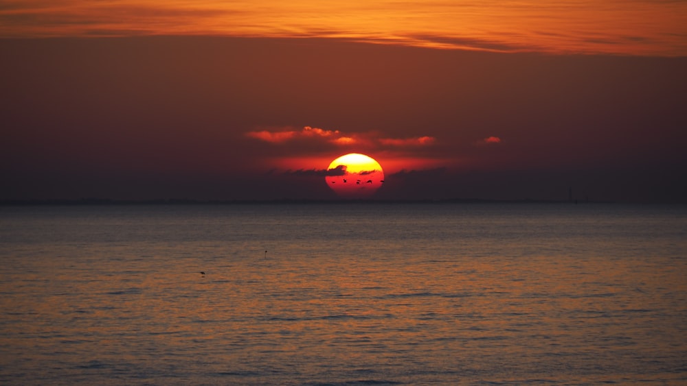 silhouette of boat on sea during sunset