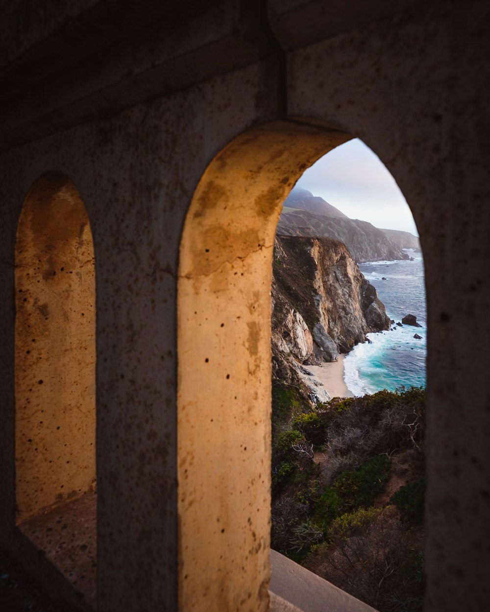 brown concrete arch near body of water during daytime