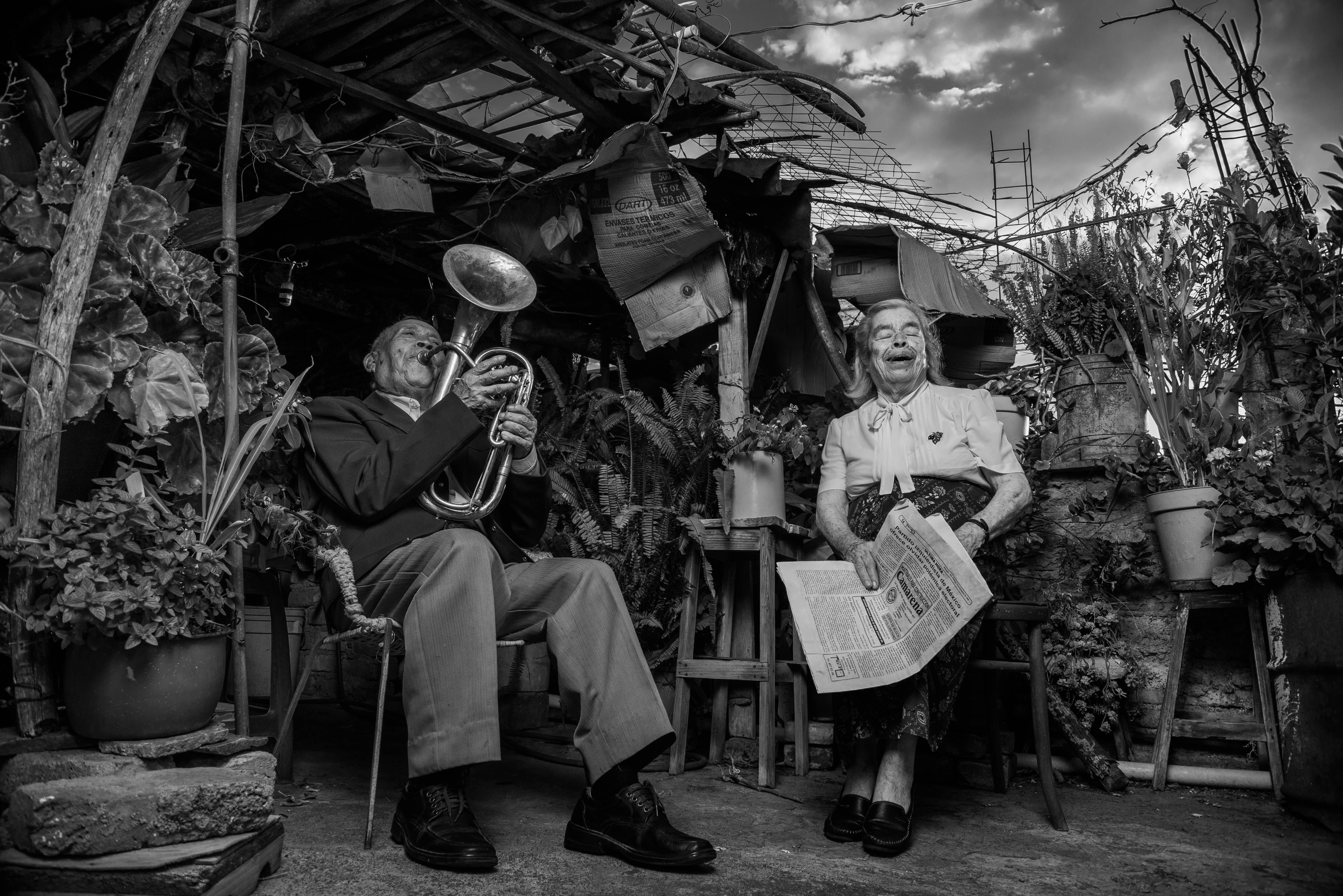 man playing trumpet sitting on chair