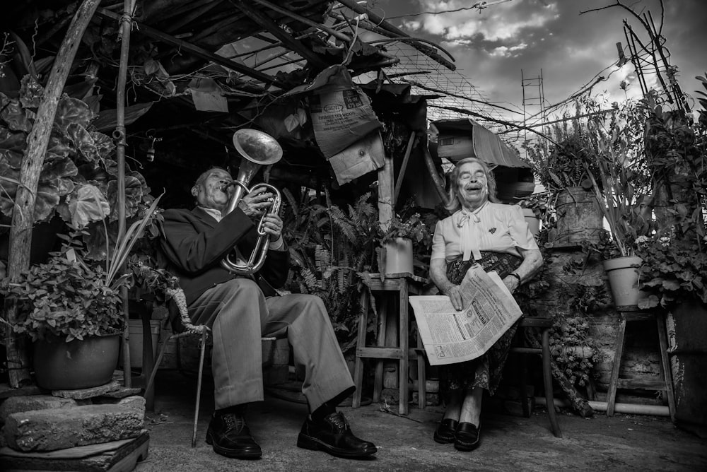 man playing trumpet sitting on chair