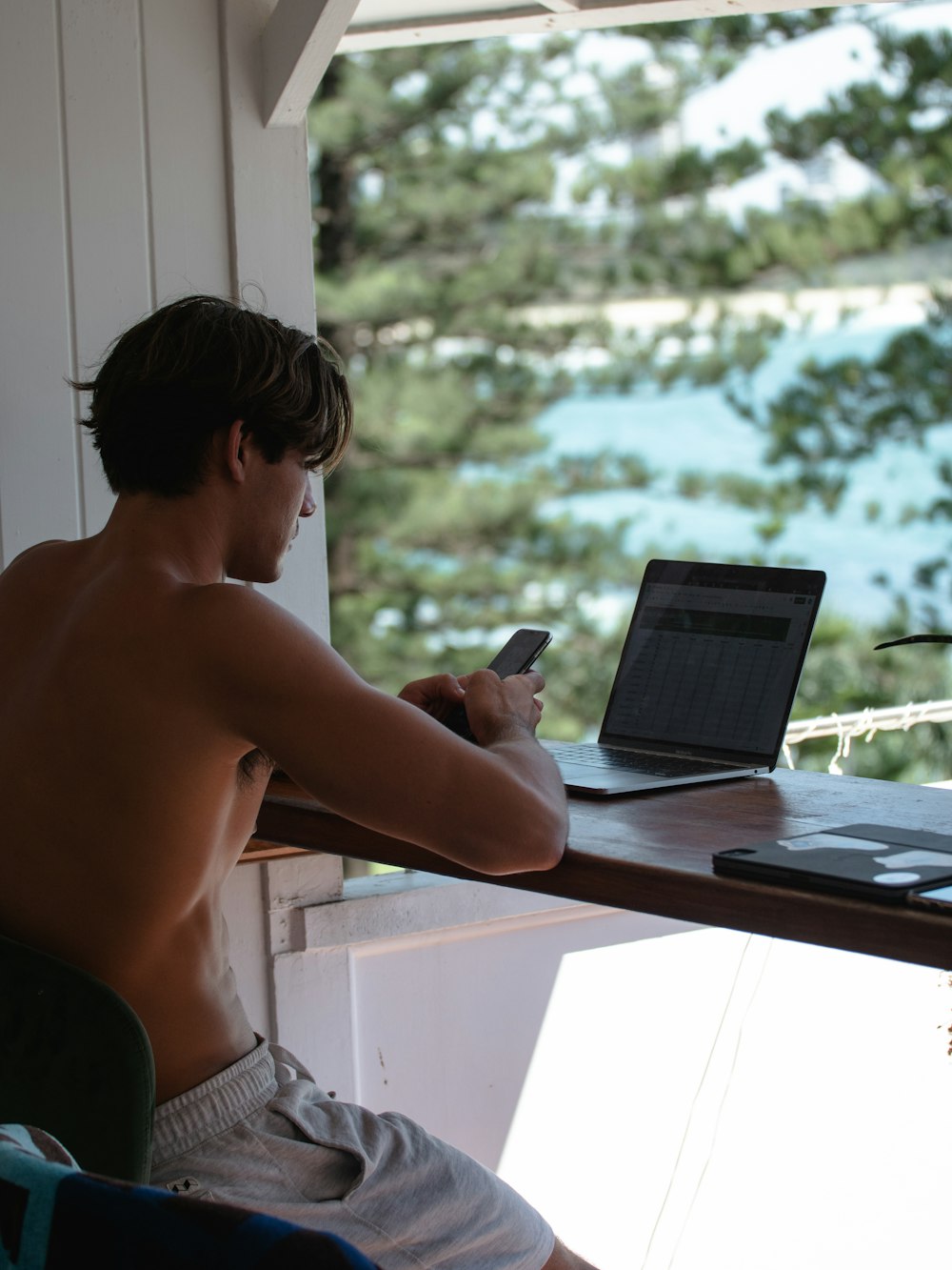 topless man using black laptop computer