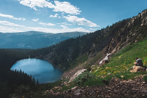 A serene landscape with a person writing in a notebook.