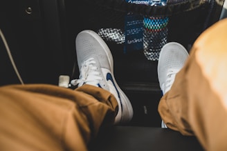 person wearing gray and white nike sneakers
