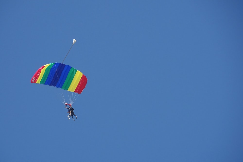 person in parachute under blue sky during daytime