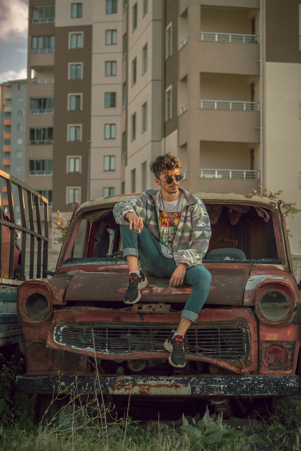 woman in blue denim jeans sitting on red car