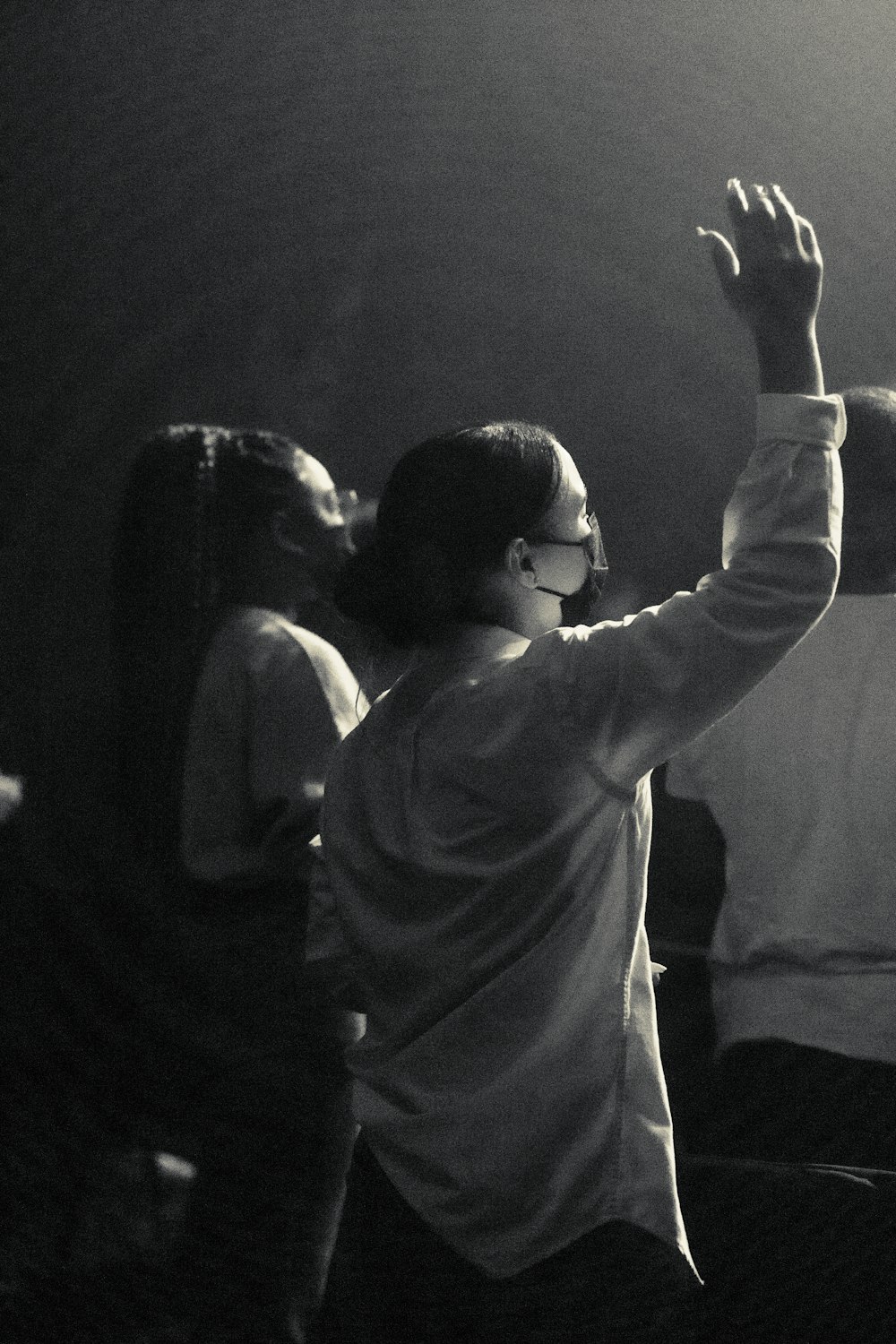 man in white long sleeve shirt raising his hand