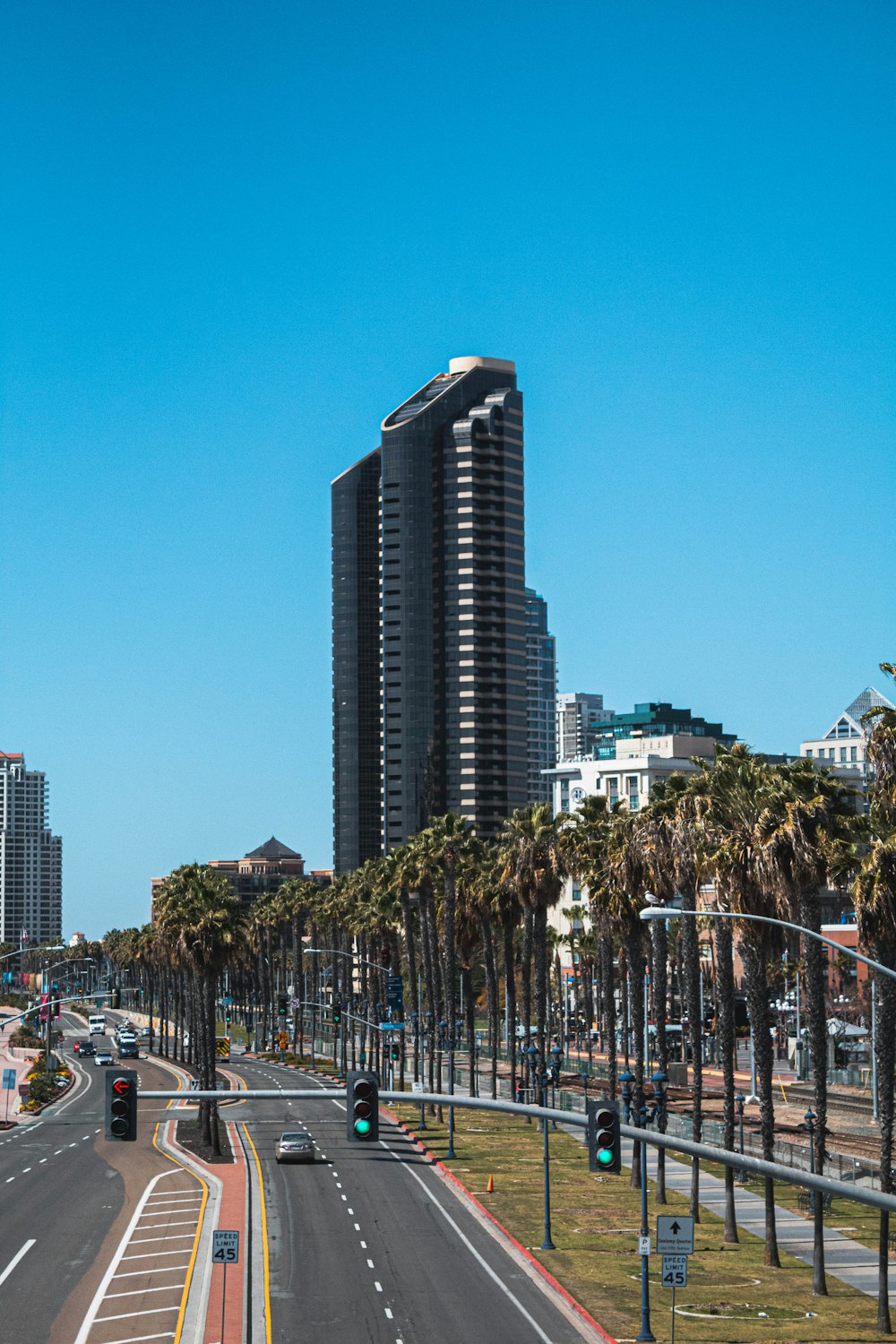 cars parked on road near high rise buildings during daytime