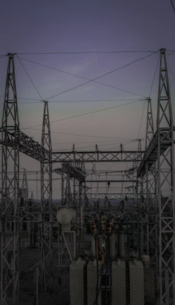 High-voltage substation with transformers and electrical infrastructure at sunset.