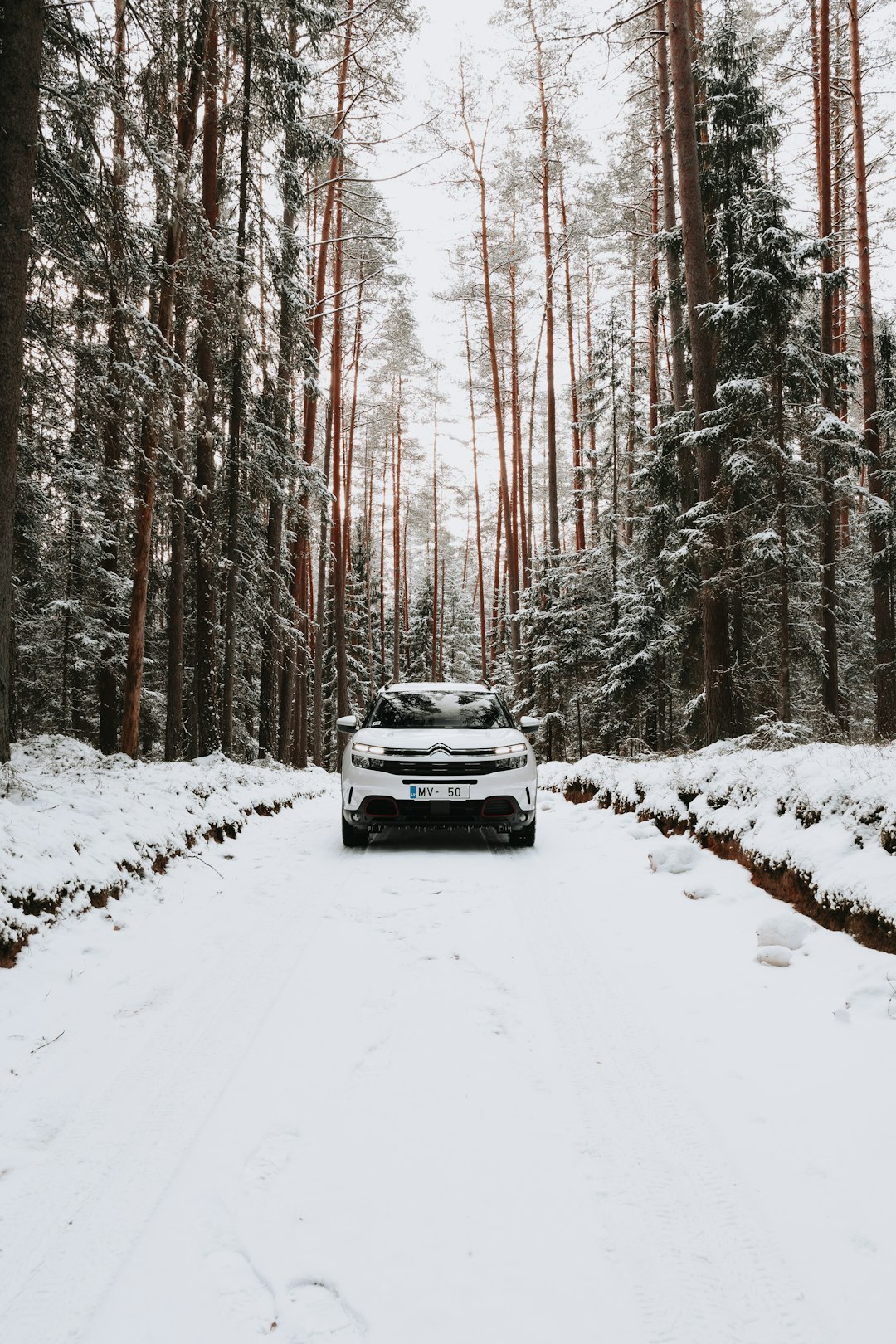 white car on snow covered road during daytime