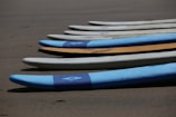 Surfboards lined up on the sand ready for rental.