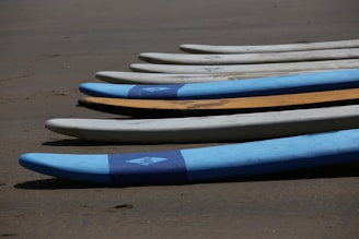 Close-up of colorful surfboards lined up on a sandy beach