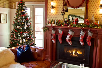 green christmas tree with baubles near fireplace