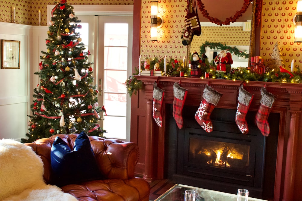 green christmas tree with baubles near fireplace