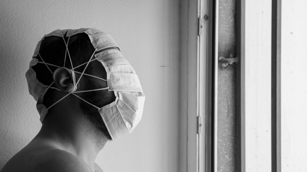 Foto in scala di grigi di una persona che indossa un cappello bianco e nero