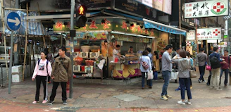 A lively street stand offering coffee and snacks with people chatting nearby.