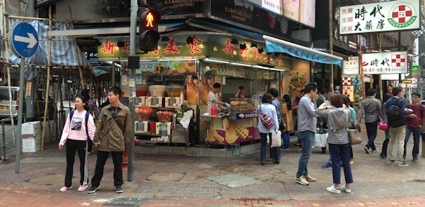 A busy street filled with people enjoying various street food delicacies.