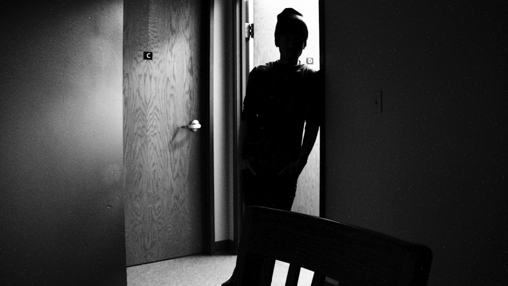 man in black long sleeve shirt standing near door