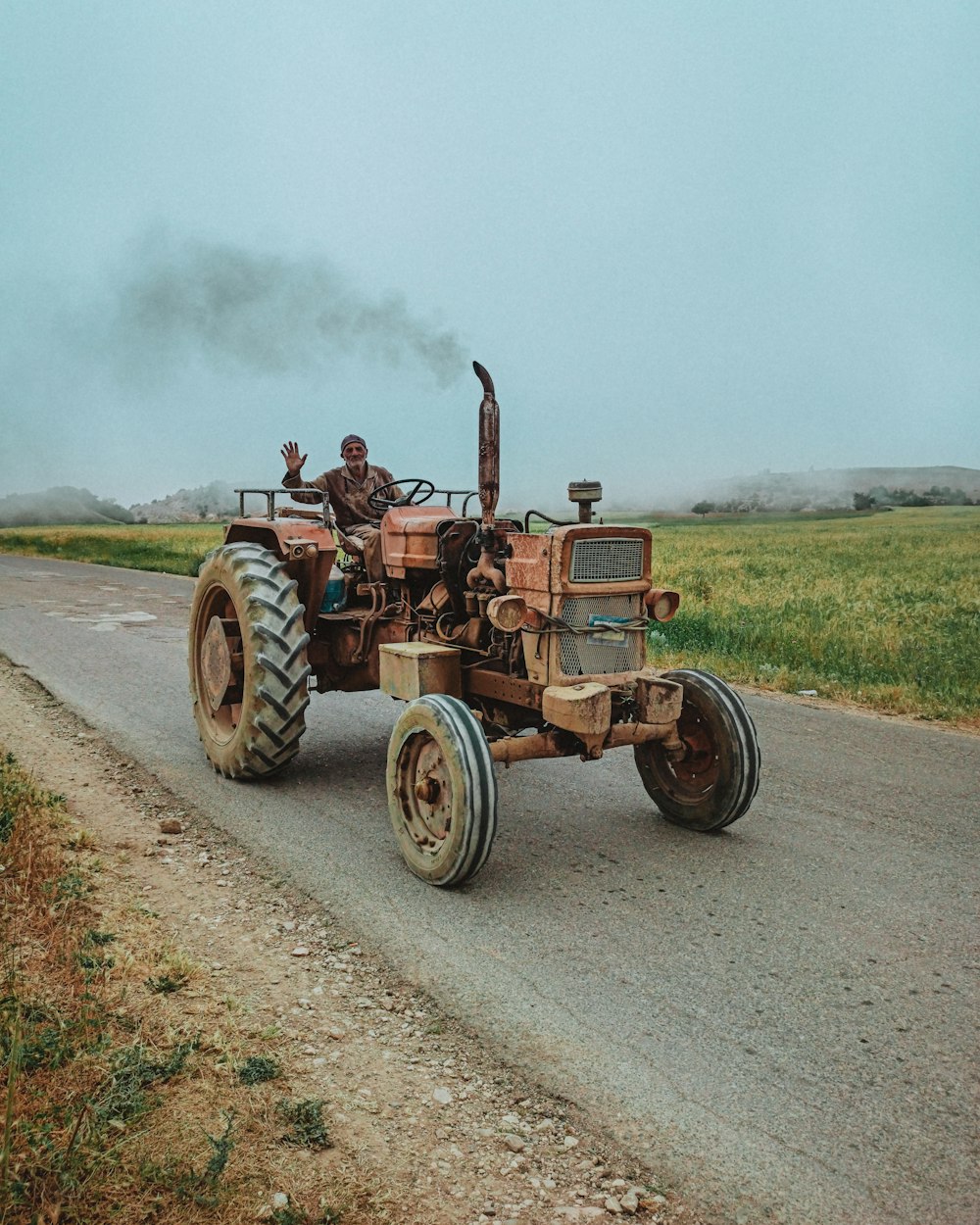 brown tractor on green grass field during daytime