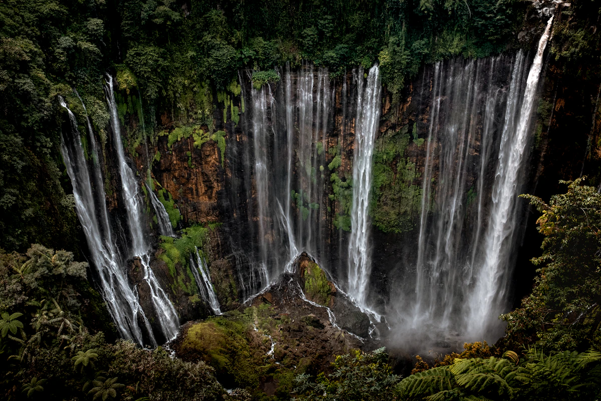 Tumpak Sewu waterfall from the panorama viewpoint at sunrise, with Semeru on the horizon