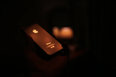 Close-up of a sleek Android gadget held in hand, glowing softly against a warm background.