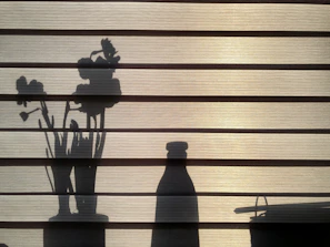 Soft shadows cast over a collection of ink bottles, paper scraps, and a small ceramic vase holding dried lavender.
